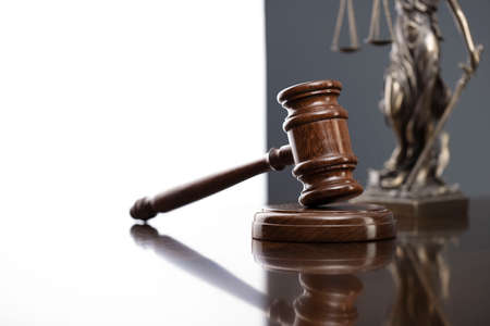 Law and justice concept. War crimes. Gavel, Themis sculpture and scale in lawyers office. Gray background.の写真素材