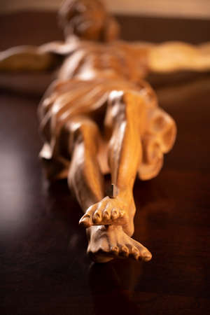 Religion theme - Jesus Christ. Cruciefied Jesus figure isolated on wooden brown background.の写真素材