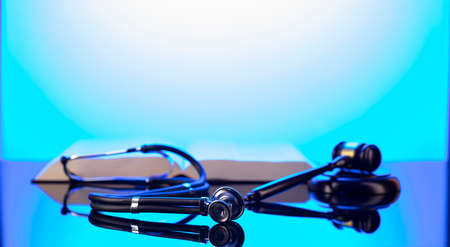 Medical law concept. Gavel, legal code and stethoscope on the glass table. Blue light.
