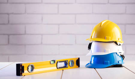 Contractor theme. Equipment of the contractor: yellow, white and blue hardhats, libella, hand saw....