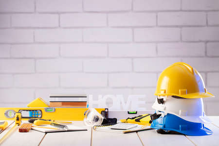 Contractor theme. Equipment of the contractor: yellow, white and blue hardhats, libella, hand saw....