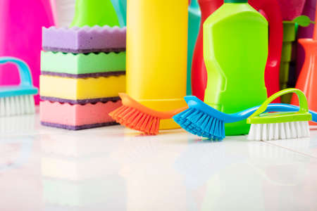 Spring house cleaning. Colorful cleaning kit on white wall background.の写真素材