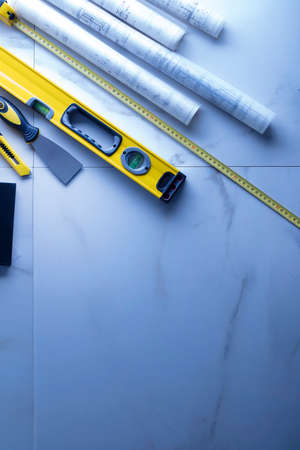 Contractor theme. Plans,  notebook and tool kit of the contractor: yellow hardhat, libella and yardstick.の写真素材