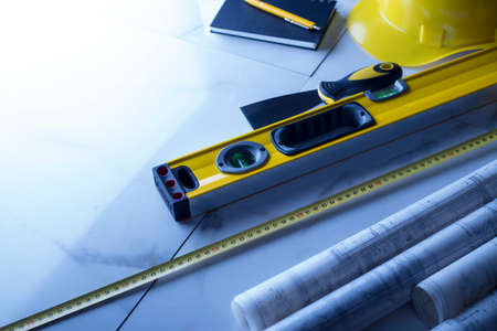 Contractor theme. Plans,  notebook and tool kit of the contractor: yellow hardhat, libella and yardstick.の写真素材