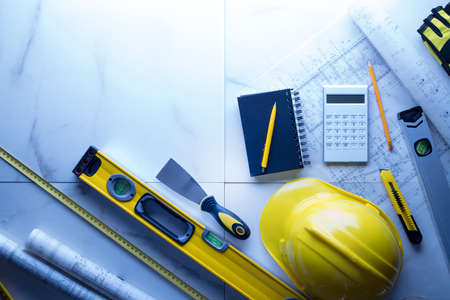Contractor theme. Plans,  notebook and tool kit of the contractor: yellow hardhat, libella and yardstick.の写真素材