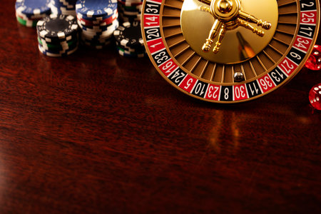 Casino. Roulette wheel, dice and poker chips on the colorful bokeh background.の写真素材