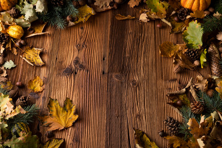 Autumn composition on a rustic wooden background. Decorative pumpkins, various leaves, 
pine cones, nuts. Orange, yellow, red  and brown aesthetics.の写真素材