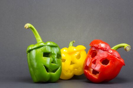 scary faces carved on bell peppers on dark background for halloween