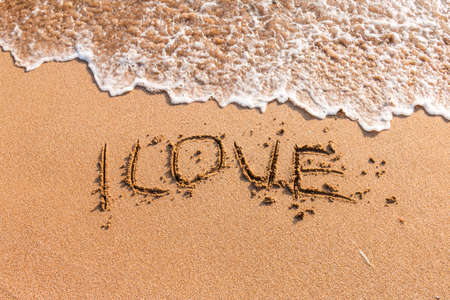 Romantic love lettering and heart sign on the beach beachの写真素材