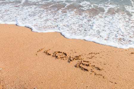 Romantic love lettering and heart sign on the beach beachの写真素材