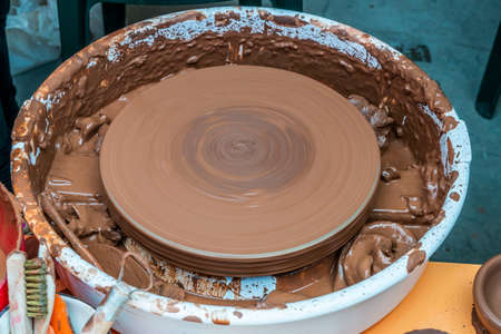 The sculptor in the workshop makes a jug out of earthenware closeup. Twisted potter's wheel.の写真素材