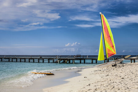 sailing boat on the beach with colorful sailsの写真素材