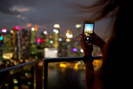 A  takes pictures of the night city from a skyscraper inの写真素材