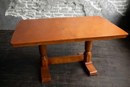 Single brown table with empty surface and carved legs in the loft interior room