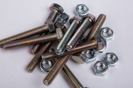 macro shot. Bolts and nuts lie on a white background. Close-up of parts for construction and repair