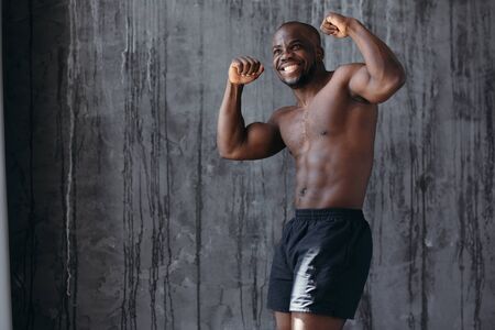 African bare-chested boxer rejoices in victory and shows bicepsの写真素材