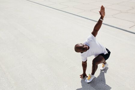 Top view of a Maracanese trainer doing lunges exercises forward with a turn of the torso on the...