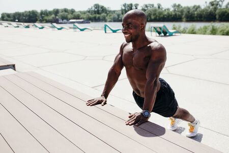 Professional pilates trainer afro-american doing stretching exercises of the spine and back muscles arching in the backの写真素材