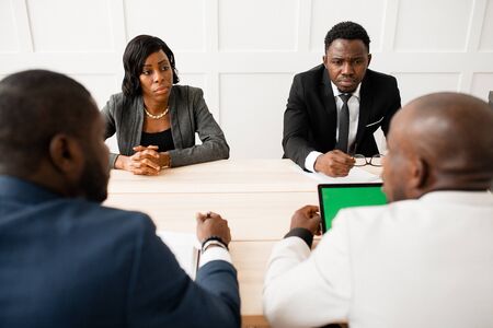 Business negotiations the two firms competitors sitting at Desk in bright office. The table sat four...