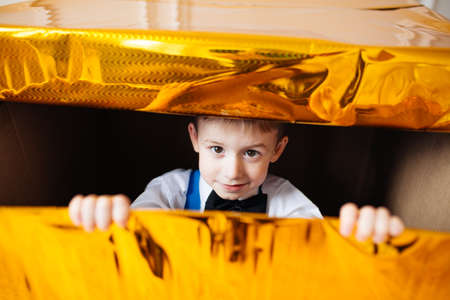 The child sits in a large New Years gift box. Christmas, family holiday, New Yearの写真素材