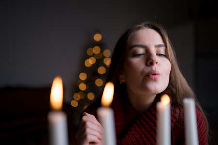 The girl blows out the Christmas candles. New year concept, holiday