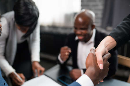 Close-up of handshake. And An African American man shakes hands with a European woman. confirmation...