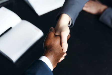Photo of shaking hands of business partners over the table. Successful completion of negotiations