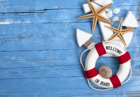 Maritime decoration with shells, starfish, sailing ship, fishing net on blue drift woodの写真素材