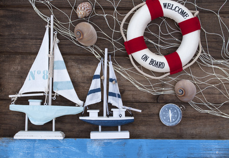 Maritime Decoration with shells, starfish, sailing ship, fishing net on blue drift wood