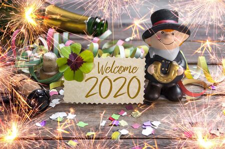 Chalkboard with four leaf clover and chimney sweeper and sparklers with happy new year 2020 on...