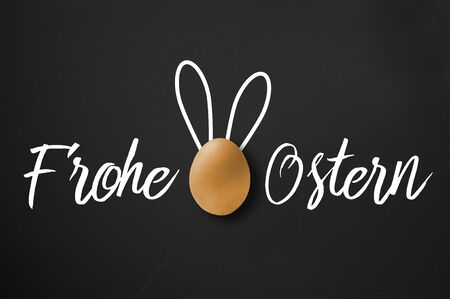 Happy easter - frohe Ostern greeting card on black chalkboard