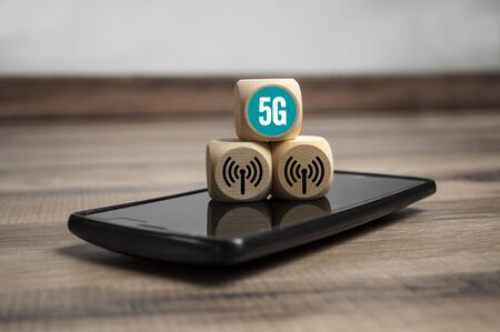 Cubes dice with 5G internet broadband standard on wooden backgroundの写真素材