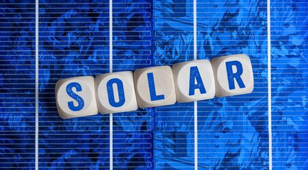 Solar energy cells with glas globe and miniature house in green grassの写真素材