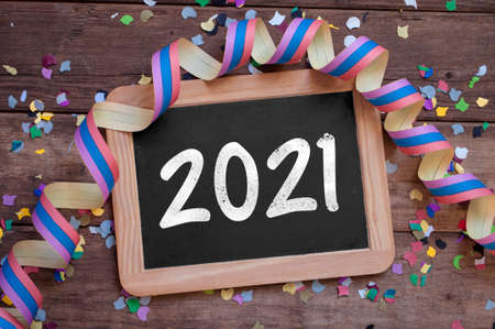 Chalkboard with four leaf clover and chimney sweeper and sparklers with happy new year 2021 on...