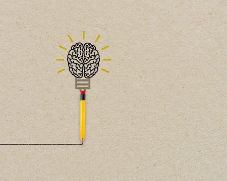 Yellow pencil with brain and light bulb metaphor for creative and new idea on brown recycled...