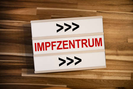 Lightbox or light box and the german word for covid-19 vaccination center or center - impfzentrum on wooden background tableの写真素材