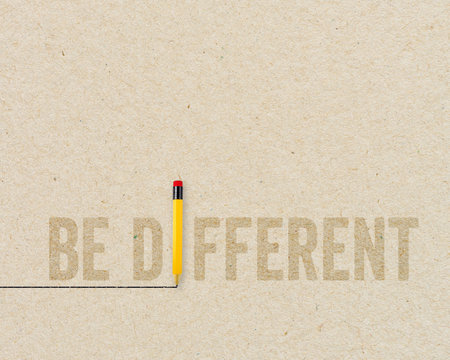 Yellow pencil with message Be different on brown recycled paper backgroundの写真素材
