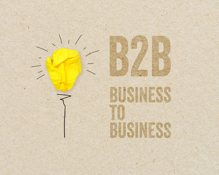 Yellow paper light bulb with B2B - Business to business on brown recycled paper backgroundの写真素材
