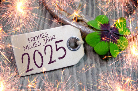 Wooden hang tag and slate with four leaf clover and sparklers with the German words for Happy New...