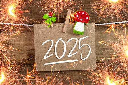 Wooden hang tag and slate with four leaf clover and sparklers with the German words for Happy New...