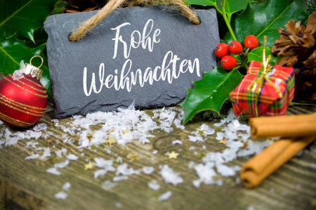 Decorative Christmas hangers in front wooden weathered background with slate plate snowflakes and merry Christmasの写真素材