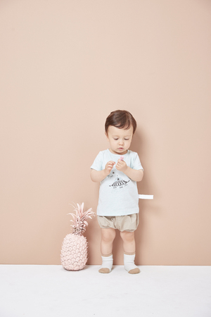 One and a half years old boy playing in front of the yellow background wall is naughty and cute.の写真素材