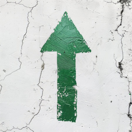 A vibrant green arrow stands out against a clean white wall, providing clear direction or guidance to anyone passing by. The contrast between the colors creates a striking visual element.の素材