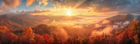 A breathtaking panoramic view of a mountainous landscape during a vibrant autumn sunrise. The suns rays illuminate the rolling hills, casting a warm glow over the dense forest, where leaves are ablaze with vibrant reds, oranges, and yellows. A thick layer of fog blankets the valleys, creating a sense of mystery and serenity. The scene captures the beauty of nature in its full glory, showcasing the majestic power of the sun rising over the mountains.の素材