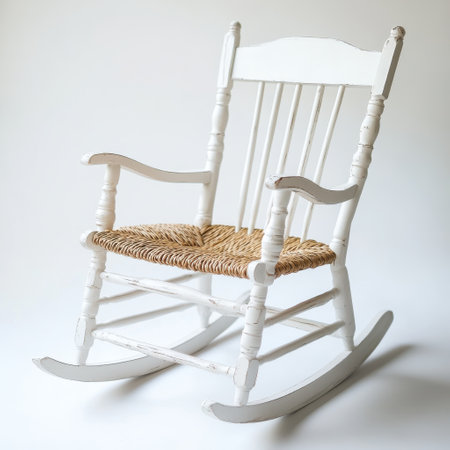A classic rocking chair featuring a white painted wood frame and a woven seat stands against a simple white backdrop. This timeless piece adds charm to any space.の素材