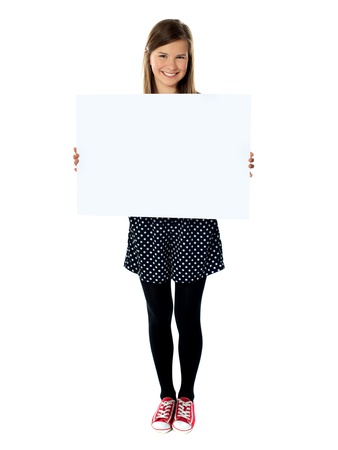 Attractive smiling cute girl holding blank poster against white backgroundの写真素材