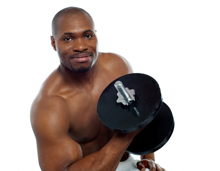 Powerful muscular young man lifting weights. Smiling at cameraの写真素材
