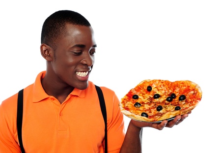 Smiling young black man holding yummy pizza against white backgroundの写真素材