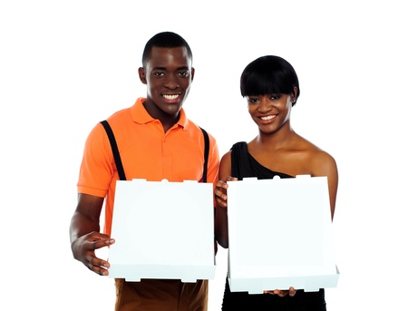 Beautiful young couple posing with open pizza boxesの写真素材