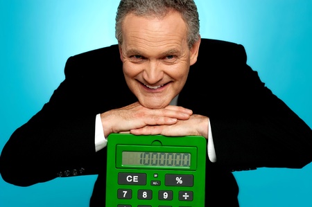 Aged corporate male resting face on big calculator looking at camera